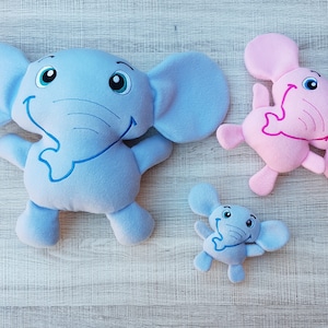May include: Three plush elephant toys. One is light blue, one is pink, and one is a smaller light blue. All have embroidered eyes and smiling mouths.