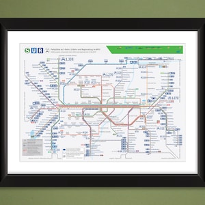 May include: Framed map of a public transportation system, featuring a detailed network of colored lines and station markers. The map includes text in German, with a green and white color scheme. The frame is black.