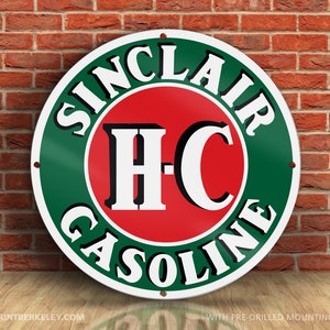 May include: A round, green and white metal sign with the text "Sinclair H-C Gasoline" in a white circle with a red center. The sign has pre-drilled mounting holes.