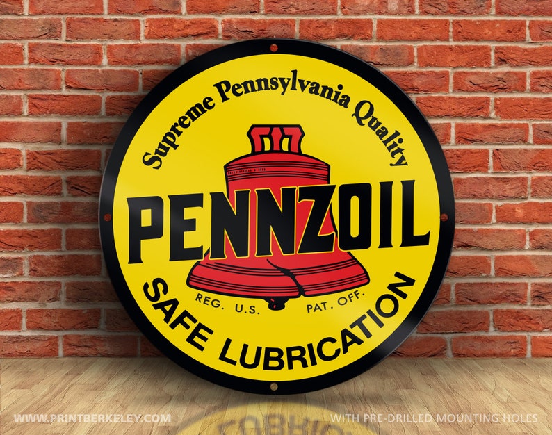 Może przedstawiać: Okrągły, metalowy znak w kolorze czarnym i ż&oacute;łtym z napisem "Supreme Pennsylvania Quality" i "PENNZOIL" czarnymi literami. Znak zawiera r&oacute;wnież dwa czerwone dzwony z napisem "U.S. PAT. OFF." i "SAFE LUBRICATION" czarnymi literami.