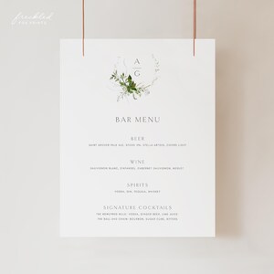 Könnte beinhalten: Eine weiße Barkarte mit grünen floralen Akzenten und den Buchstaben "AG" in einem Kranz. Die Karte listet Bier, Wein, Spirituosen und Signature-Cocktails auf.