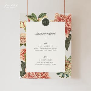 Puede incluir: Un menú de cócteles con un panel central blanco que muestra "signature cocktails". El menú incluye las recetas "Old Fashioned" y "Moscow Mule". El diseño incorpora elementos florales rosas y verdes.