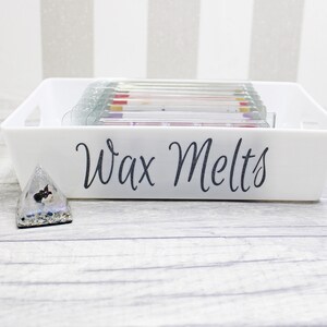 May include: White rectangular tray with the text "Wax Melts" on the front. The tray is filled with small, colorful wax melts.