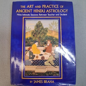 May include: A blue hardcover book titled The Art and Practice of Ancient Hindu Astrology: Nine Intimate Sessions Between Teacher and Student by James Braha. The cover features a detailed illustration of people sitting in a garden.