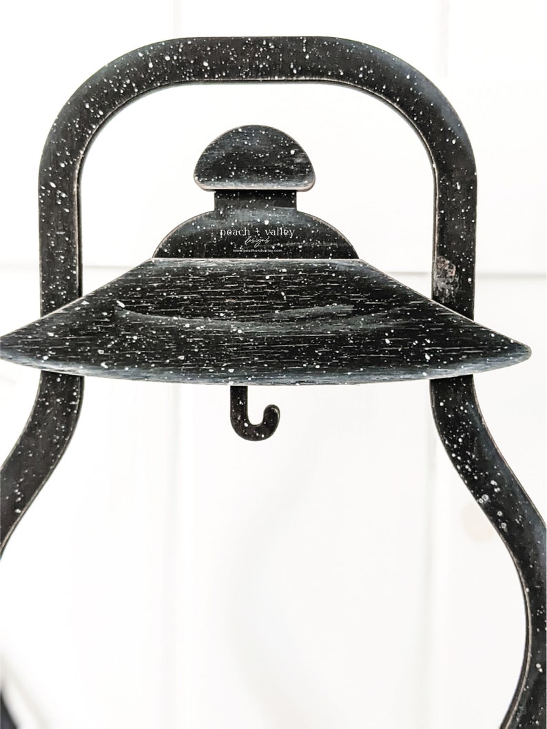 May include: Black metal lantern with a hook on the bottom and a white speckled finish. The lantern has a round top with a small dome and the text "peach + valley" is visible on the top.