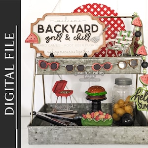 May include: A two-tiered metal stand with a red and white checkered background. The top tier has a wooden sign that says "Welcome Backyard Grill & Chill Yard Games - Root Beer Floats Making Memories Together". The bottom tier has a variety of summer-themed decorations, including a red grill, a hamburger, a mason jar, and a watermelon garland.