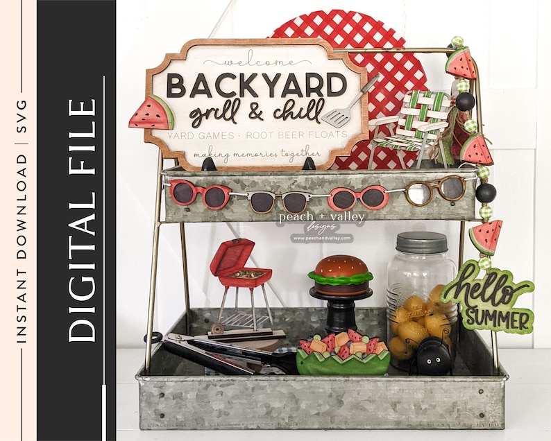 May include: A two-tiered metal stand with a red and white checkered background. The top tier has a wooden sign that says "Welcome Backyard Grill & Chill Yard Games - Root Beer Floats Making Memories Together". The bottom tier has a variety of summer-themed decorations, including a red grill, a hamburger, a mason jar, and a watermelon garland.