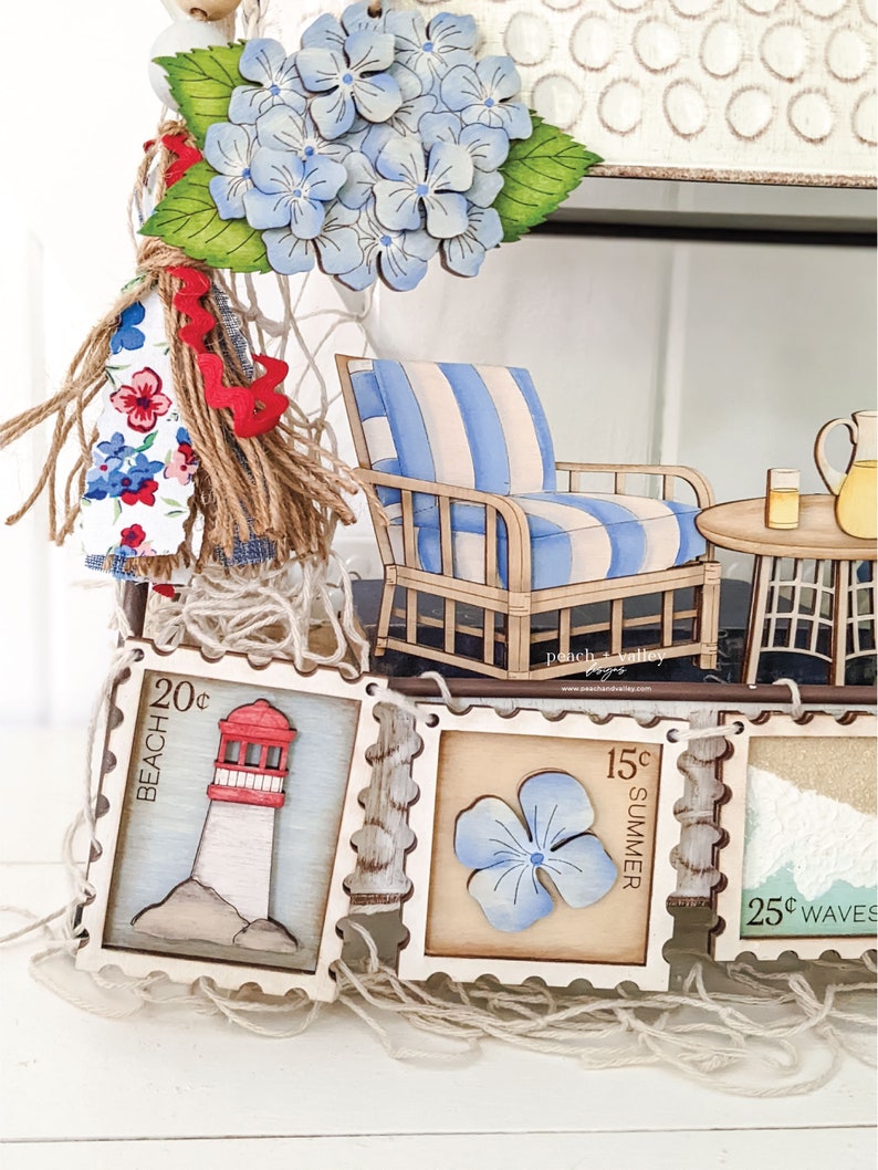 May include: A wooden banner with five decorative stamps featuring a lighthouse, a flower, and the words "Beach 20c", "Summer 15c", and "Waves 25c".