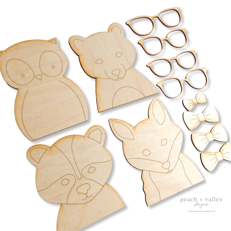 May include: Wooden craft kit featuring animal faces, including an owl, fox, raccoon, and bear. The kit also includes three pairs of glasses and three bowties. The kit is designed for painting and decorating.