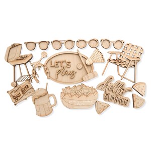 May include: A set of 14 laser cut wooden shapes for crafting projects. The shapes include a grill, horseshoe, sunglasses, a chair, a watermelon, a root beer float, a sign that says "Root Beer Floats", a sign that says "Let's Play", a bowl of fruit, a badminton racket, a croquet mallet, and a sign that says "Hello Summer".