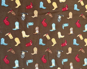 Peut inclure: Un tissu brun avec un motif répétitif de bottes de cowboy colorées. Les bottes sont de différentes couleurs, notamment rouge, bleu, jaune et marron.