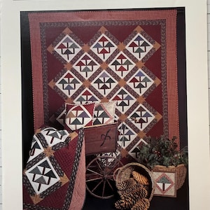 May include: A brochure titled "Pine Grove" featuring a quilt with a repeating tree pattern in red, brown, and white. The image includes matching pillows, a small quilt, a wooden cart, pine cones, and a basket. The text "thimbleberries" is at the bottom.