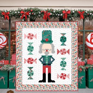 Puede incluir: Un patrón de edredón titulado "Nutcracker Sweet" con un diseño central de un soldado cascanueces y motivos de caramelos. El edredón mide 153,7 cm por 171,5 cm. El diseño incluye colores rojo, verde y blanco, con un tema festivo.
