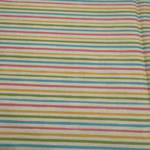 May include: Close-up of a fabric with a repeating pattern of horizontal stripes. The stripes alternate in color, including pink, green, blue, and yellow, against a white background. The fabric appears to be cotton or a similar material.