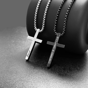 May include: Two silver cross necklaces. One cross has the name "David" engraved on it. The other cross has the text "CONFIRMED IN CHRIST 5:24" engraved on it.