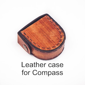May include: A brown leather case with a stitched edge for a compass. The case has a flap that closes with a snap.