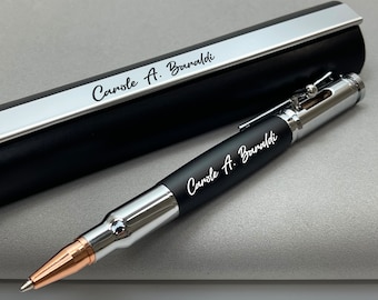 May include: A black and silver bullet pen with a black leather case. The pen is engraved with the name "Carole A. Baraldi".