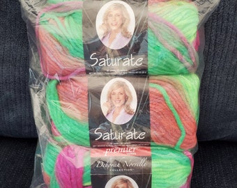May include: Two skeins of green, pink, and orange yarn with a label that reads "Saturate premier yarns Deborah Norville Collection".