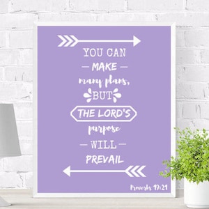 Könnte beinhalten: Lilafarbener Druck mit inspirierenden Zitat in weißer Schrift: "Du kannst viele Pläne machen, aber der Plan des Herrn wird sich durchsetzen." Das Zitat stammt aus Sprichwörter 17:21.
