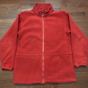 May include: A red fleece jacket with a zipper closure and a drawstring waist.