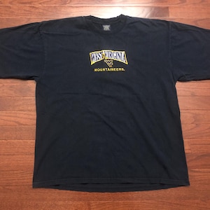 May include: A navy blue t-shirt with a yellow and blue embroidered logo that says "West Virginia Mountaineers."