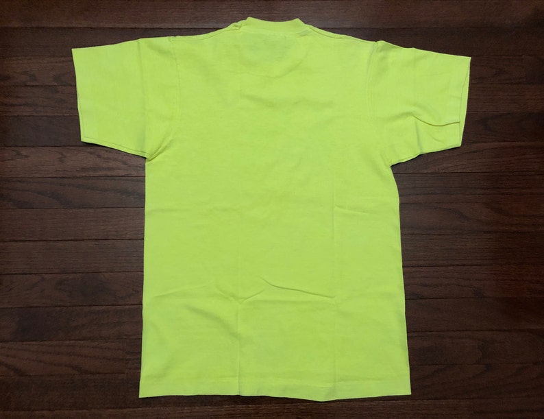 May include: A bright neon yellow t-shirt. The shirt is a basic crew neck style with short sleeves.