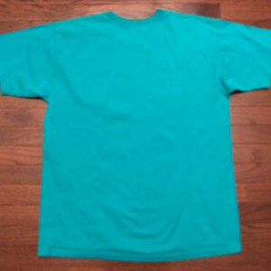 May include: A turquoise blue t-shirt with short sleeves.