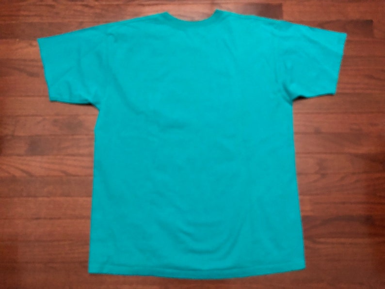 May include: A turquoise blue t-shirt with short sleeves.
