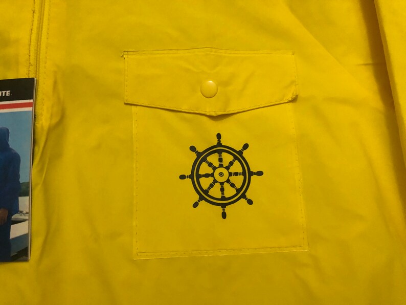 May include: A yellow raincoat with a black steering wheel logo on the front pocket. The pocket has a yellow button.