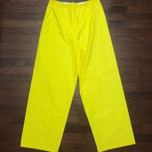 May include: A pair of bright yellow waterproof pants. The pants have an elastic waistband and are made of a smooth, shiny material.