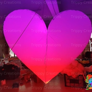Glowing LED inflatable love heart, perfect for romantic events.