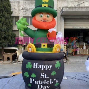 May include: An inflatable leprechaun figure wearing a green hat and suit, holding a shamrock and a mug of beer. The figure sits atop a black pot with "Happy St. Patrick's Day" text and shamrock graphics.