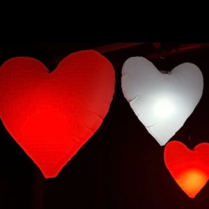 Large LED inflatable heart glowing beautifully at an outdoor event.