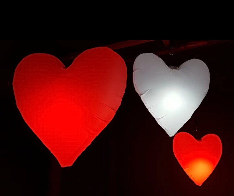 Large LED inflatable heart glowing beautifully at an outdoor event.