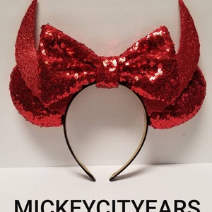 May include: Red sequined Minnie Mouse ears with a large red bow and devil horns.