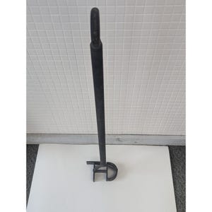 May include: A black branding iron with a long handle and a loop at the top. The branding iron has the letters "TD" at the bottom. The iron is made of metal and is used for marking livestock.