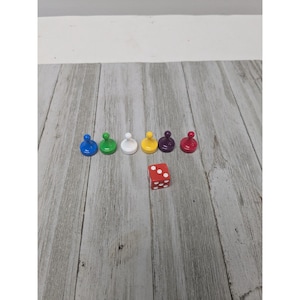 May include: A set of six game pieces in different colors: blue, green, white, yellow, purple, and red. A red die with white dots is also included.