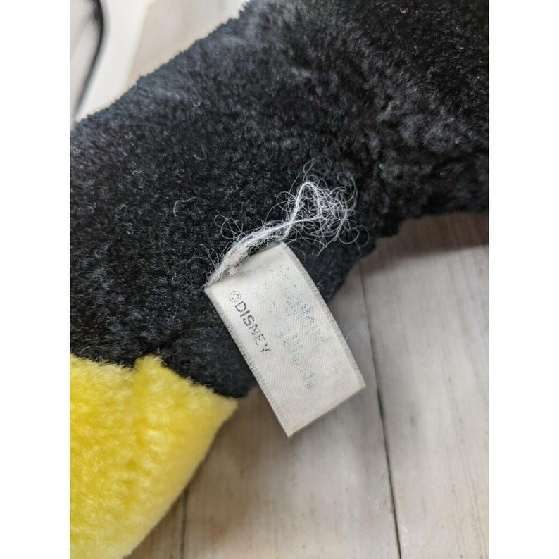 May include: Close-up of a black and yellow plush toy with a white tag that reads "&copy;DISNEY".