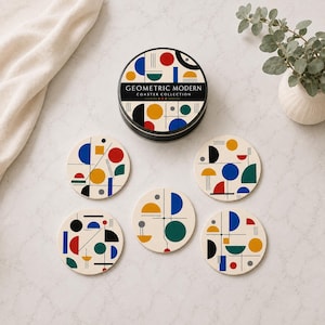 May include: A set of five round coasters and a matching circular storage tin, all featuring a cream background with a colorful geometric pattern of circles, semicircles, and lines in red, blue, yellow, green, and black. The tin lid reads GEOMETRIC MODERN COASTER COLLECTION.