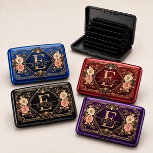 May include: Four rectangular card cases in blue, black, red, and purple, each featuring a gold geometric frame, floral accents, and the letter E with the name EVELYN printed below. One case is shown open, revealing a black accordion-style interior.