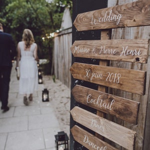 Richtingsborden in pallethout en verf om te personaliseren voor bruiloften en feesten