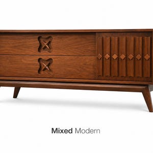May include: A mid-century modern wooden dresser with two drawers and a sliding door. The drawers feature carved starburst designs, while the door has vertical grooves and diamond accents. The dresser is supported by angled legs and the text "Mixed Modern" is visible.
