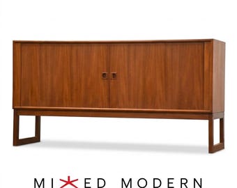 May include: A rectangular wooden sideboard featuring two cabinet doors with recessed handles, supported by four straight legs. The wood grain is visible across the surface. The text "MIXED MODERN" with a red star icon is below the furniture.