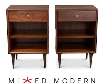May include: A pair of dark brown wooden nightstands, each featuring a single top drawer with a small circular knob, an open storage shelf below, and four tapered legs. The text MIXED MODERN is printed in black and red below the furniture.