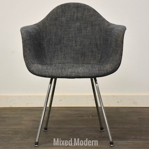May include: A gray upholstered armchair with chrome legs. The chair has a simple, modern design.