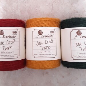 May include: Three spools of Everlasto Jute Craft Twine in red, orange, and dark green. Each spool is labelled with the brand name, product description, and a graphic of a ball of twine. The twine is approximately 50 metres.