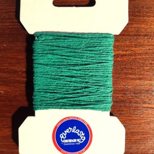 May include: A spool of green cotton thread with a white label that says "Everlast" and "Established 1856".