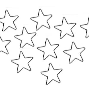 May include: Ten black metal star-shaped cutouts, arranged in a loose, asymmetrical pattern on a white background.
