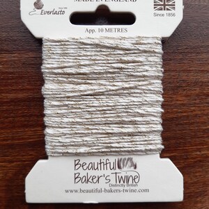 May include: A spool of white baker's twine with gold glitter, labelled "Beautiful Baker's Twine" and "Distinctly British". The spool is approximately 10 metres long and made in England.