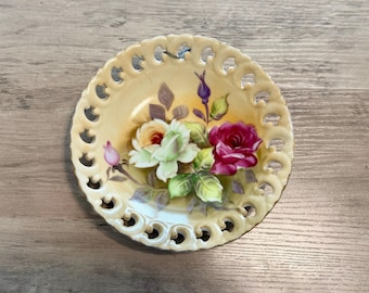 Vintage porcelain dish features delicate hand-painted roses and a pierced, reticulated rim. Made in Japan with 18 karat Gold edging